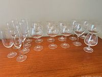 Group of assorted wine glasses and champagne flutes on wooden surface