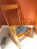 Full view of wooden rocking chair with braided cushion