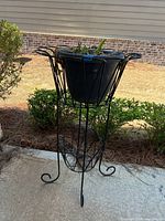 Full view of metal plant stand with plastic pot outdoors