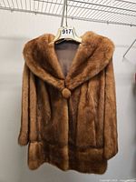 Front view of brown mink hip-length coat on hanger