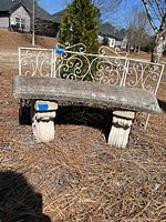 Front view showing concrete bench seat on two fluted legs with separate metal scroll back rail