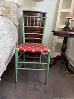 Front view of green faux bamboo chair between bedside and side table