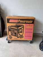 Boxed Coleman Powermate Pro-Gen 5000 generator on dolly