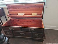 Chest open showing cedar interior, shelf, paperwork