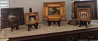 Full lot view of four framed miniature paintings on stands