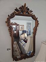 Full view of ornate gold gilt wall mirror on wall