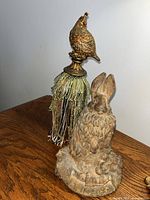 Rabbit figurine and bird finial tassel on table