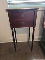 Full view of mahogany veneer side table with two drawers and turned legs