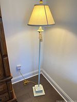 Full view of white/cream metal floor lamp with shade and cord