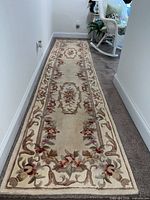 Full view of ivory and beige wool floral runner rug on hallway floor