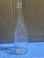 Full view of clear glass soda bottle standing upright