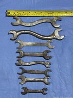 All eight wrenches lined up beside tape measure for scale