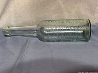 Full side view of bottle showing overall shape and aqua tint.