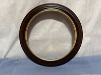 Front view showing wood finish and gold inner rim