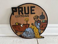 Front of round Prue Cottons wooden sign showing full artwork and lettering