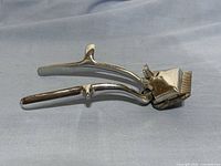 Left side profile of the clippers showing handles and cutting head