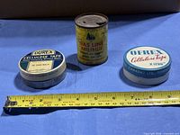Group shot of all three tins with tape measure for scale