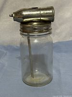 Overall view showing glass jar and attached metal spray head