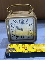 Front view showing brass case, dial, carry handle and size reference