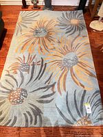 Full view of rectangular floral wool rug on hardwood floor