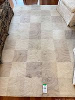 Full view of rectangular checkered rug on hardwood floor