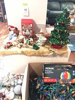 Overview of lot showing tabletop tree, figurines, boxed lights, ornaments