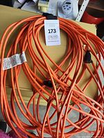 Coiled orange extension cord showing plug and length