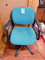 Front view of teal fabric office chair on casters
