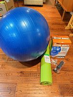 Blue exercise ball, green mat, pump, box overview