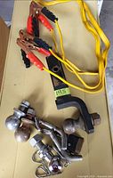 group shot: booster cables, hitch mount with ball, loose balls, coupler lock