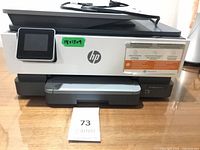 Front view of HP OfficeJet 8022e printer showing touchscreen, output tray and model label