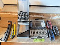 Full lot view with drill bit index, driver bit set, pruning saw, utility knife, three folding key sets