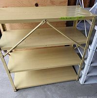 Front view of beige metal shelving unit with four shelves