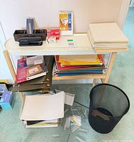 Overall view: stapler, desk caddy, paper stacks, letter trays, wastebasket