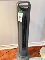 Full view of gray Seville Classics tower fan on circular base