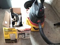 Vacuum with hose, box of attachments and filters