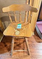 Front angle of swivel wooden chair showing seat, backrest, legs