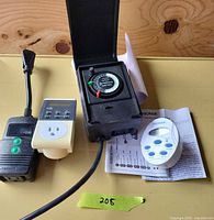 Group shot of four timers including analog dial unit, black digital controller, Garrison timer, Noma timer