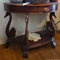 Full view of demi-lune table showing swan legs, drawer and lower shelf