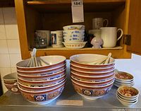Cabinet showing entire assortment of bowls, spoons and mugs