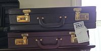 Two stacked briefcases showing colors, handles, brass combination locks