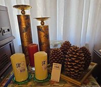 overall lot showing metal candle holders, assorted candles, pinecone candles, plates