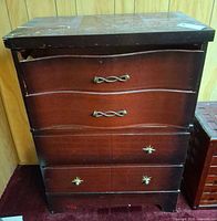 Front view of wooden chest showing five drawers, handles, missing knob, overall finish