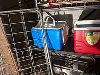 Coleman cooler, Igloo cooler, metal cart together on shelving