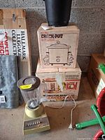 Stacked Rival Crock-Pot and Hamilton Beach slow cooker boxes, Presto Fry Daddy pot on top, Hamilton Beach blender at front
