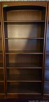 Front view of dark brown veneer bookcase showing five shelves