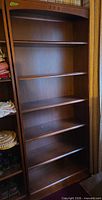 Full frontal view of the dark brown veneer bookcase showing all five shelves