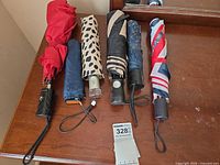 All six folded umbrellas laid out side by side