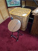 Wicker hamper beside folding stool