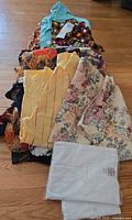 Stack of assorted ethnic patterned women’s tops plus one packaged white top